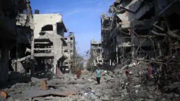 Des Palestiniens, dont certains sont blessés ou ont récupéré leurs biens, traversent le quartier d'Al-Karama qui a été détruit par les frappes aériennes israéliennes ; ville de Gaza. Les forces coloniales israéliennes continuent de pilonner la bande de Gaza pour la cinquième journée. Les frappes aériennes israéliennes ont tué au moins 1300 Palestiniens et déplacé plus de 300 000 personnes. Pour beaucoup, il s'agit d'un deuxième ou d'un troisième déplacement, puisque la majorité des habitants de Gaza sont des réfugiés de toute la Palestine. Les forces coloniales israéliennes ont également décrété un siège total de la bande de Gaza, privant les deux millions d'habitants de l'enclave d'accès à la nourriture, à l'eau, au carburant et à l'électricité - Photo : Mohammed Zaanoun/ Activestills