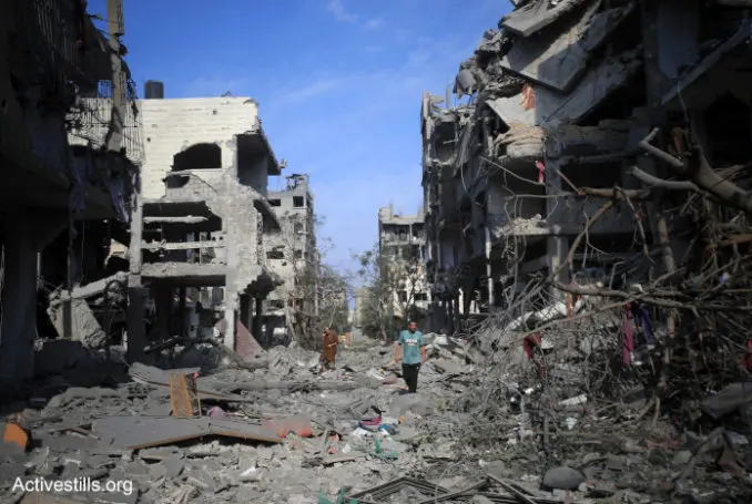 Des Palestiniens, dont certains sont blessés ou ont récupéré leurs biens, traversent le quartier d'Al-Karama qui a été détruit par les frappes aériennes israéliennes ; ville de Gaza. Les forces coloniales israéliennes continuent de pilonner la bande de Gaza pour la cinquième journée. Les frappes aériennes israéliennes ont tué au moins 1300 Palestiniens et déplacé plus de 300 000 personnes. Pour beaucoup, il s'agit d'un deuxième ou d'un troisième déplacement, puisque la majorité des habitants de Gaza sont des réfugiés de toute la Palestine. Les forces coloniales israéliennes ont également décrété un siège total de la bande de Gaza, privant les deux millions d'habitants de l'enclave d'accès à la nourriture, à l'eau, au carburant et à l'électricité - Photo : Mohammed Zaanoun/ Activestills