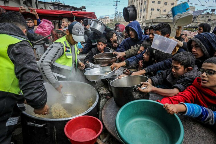 Des Palestiniens attendent un repas chaud préparé par des bénévoles à Rafah, dans le sud de la bande de Gaza, le 26 janvier 2024. (Abed Rahim Khatib/Flash90)